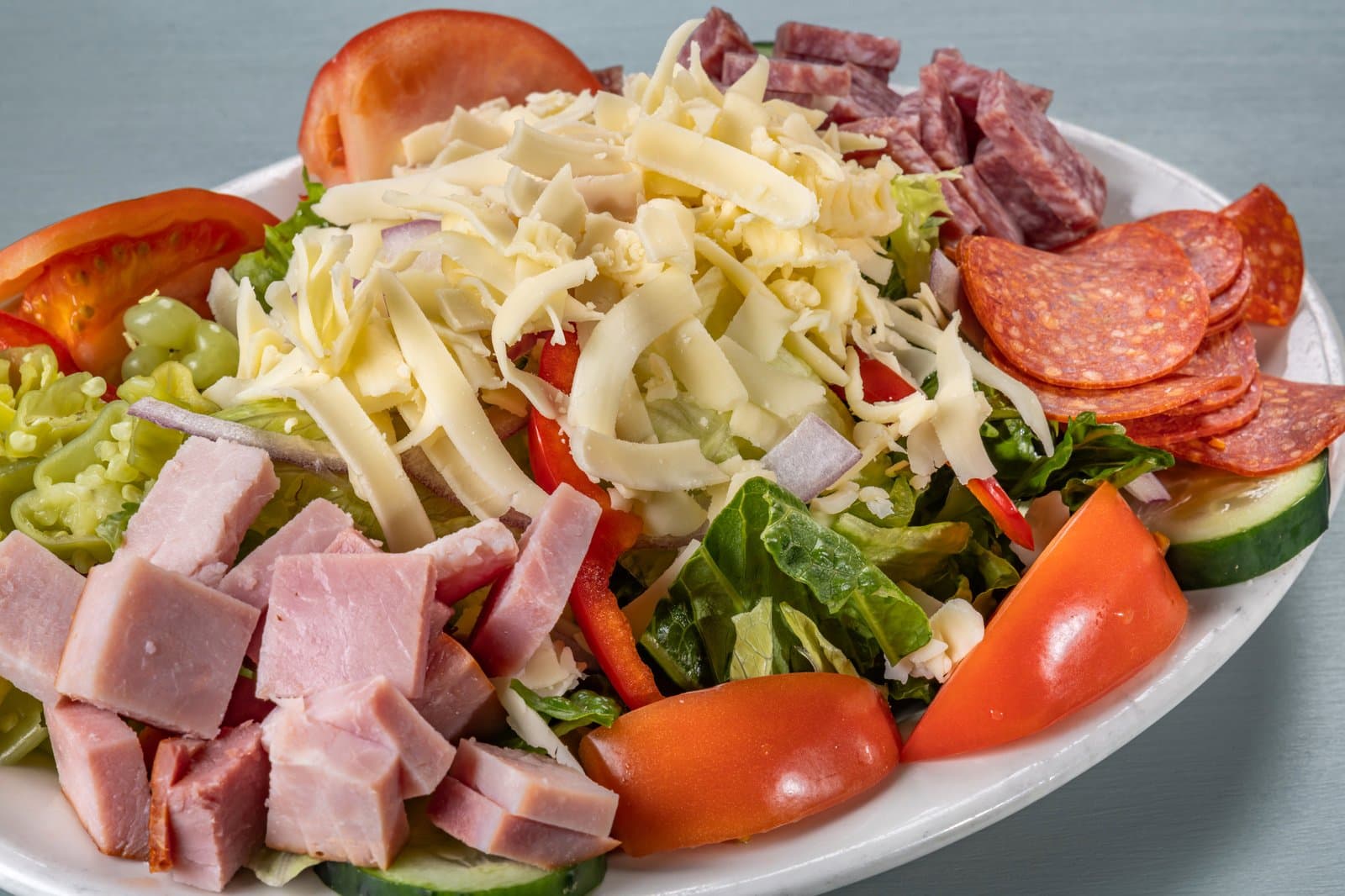 Antipasto salad with ham, salami, pepperoni, and shredded cheese