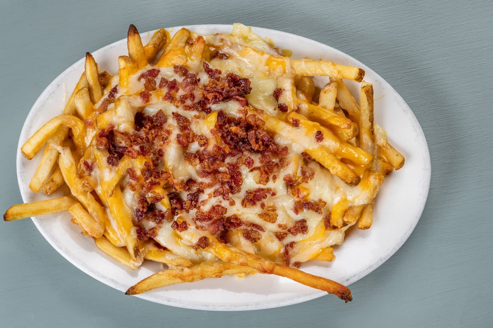 Fries smothered in melted cheese and crispy bacon