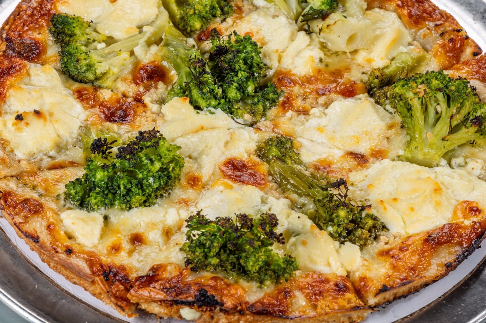 White pizza topped with roasted broccoli and ricotta