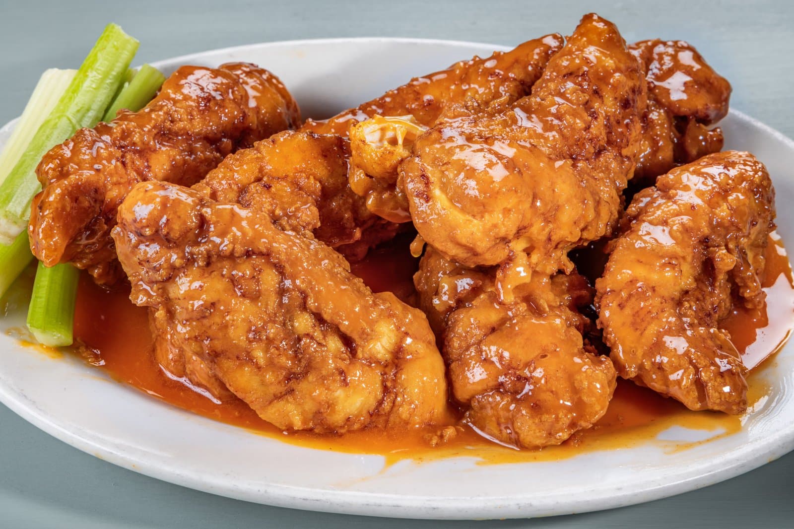 Buffalo chicken tenders glazed in sauce with celery sticks