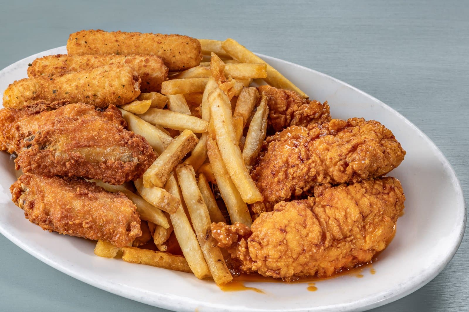 Appetizer platter with mozzarella sticks, wings, buffalo tenders, and fries