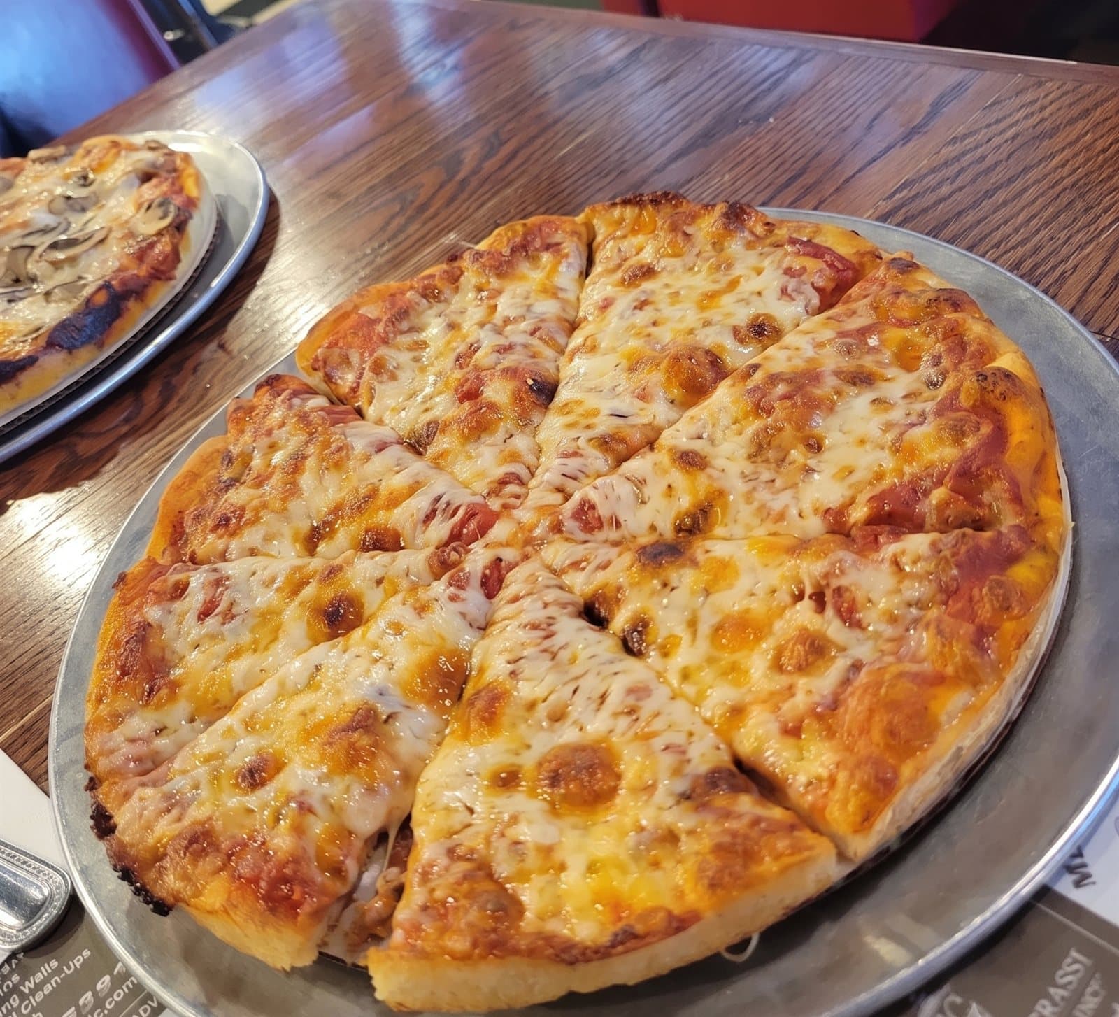Classic cheese pizza, sliced and golden, on a silver tray