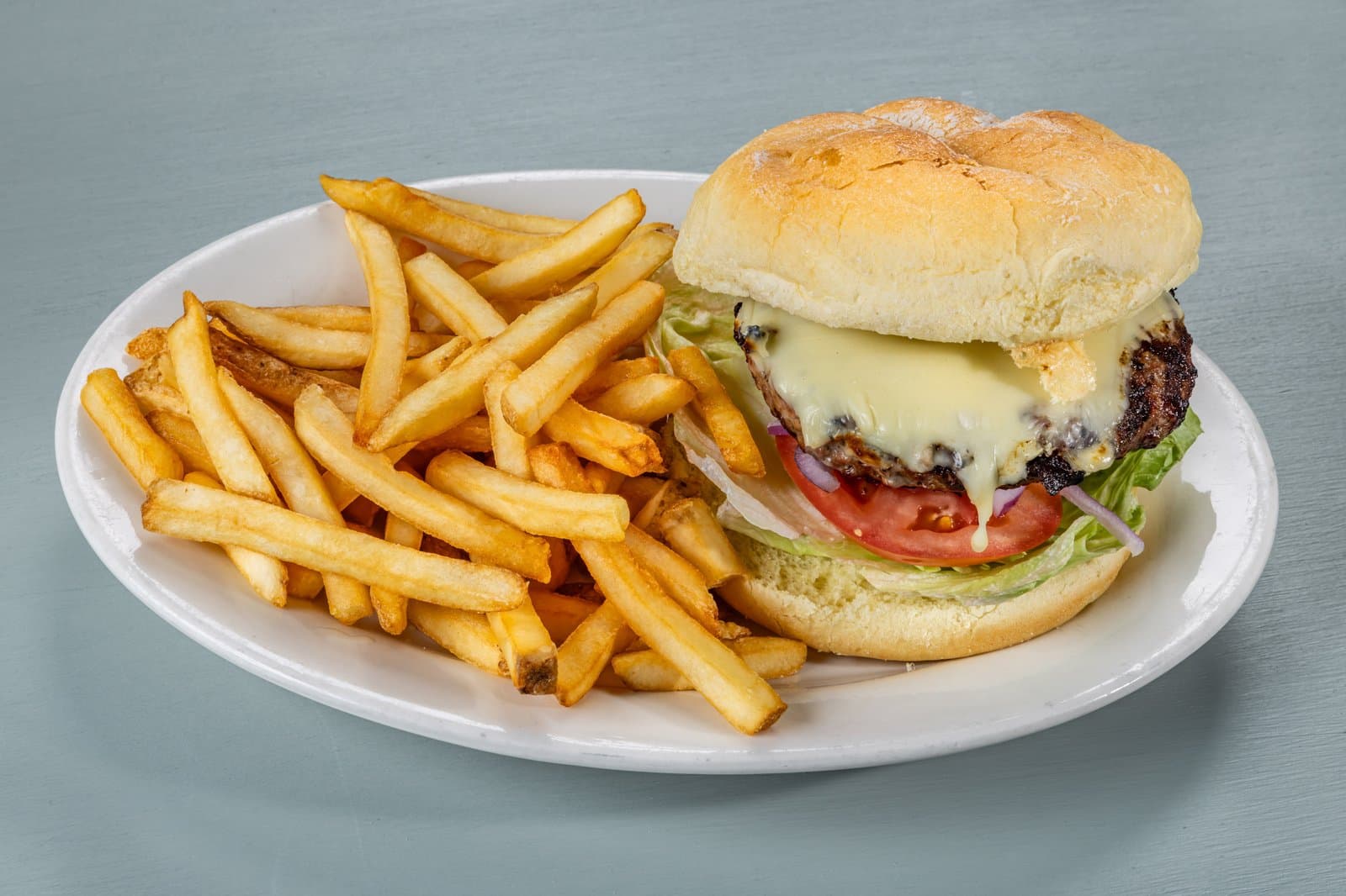 Classic cheeseburger with fries on an oval plate