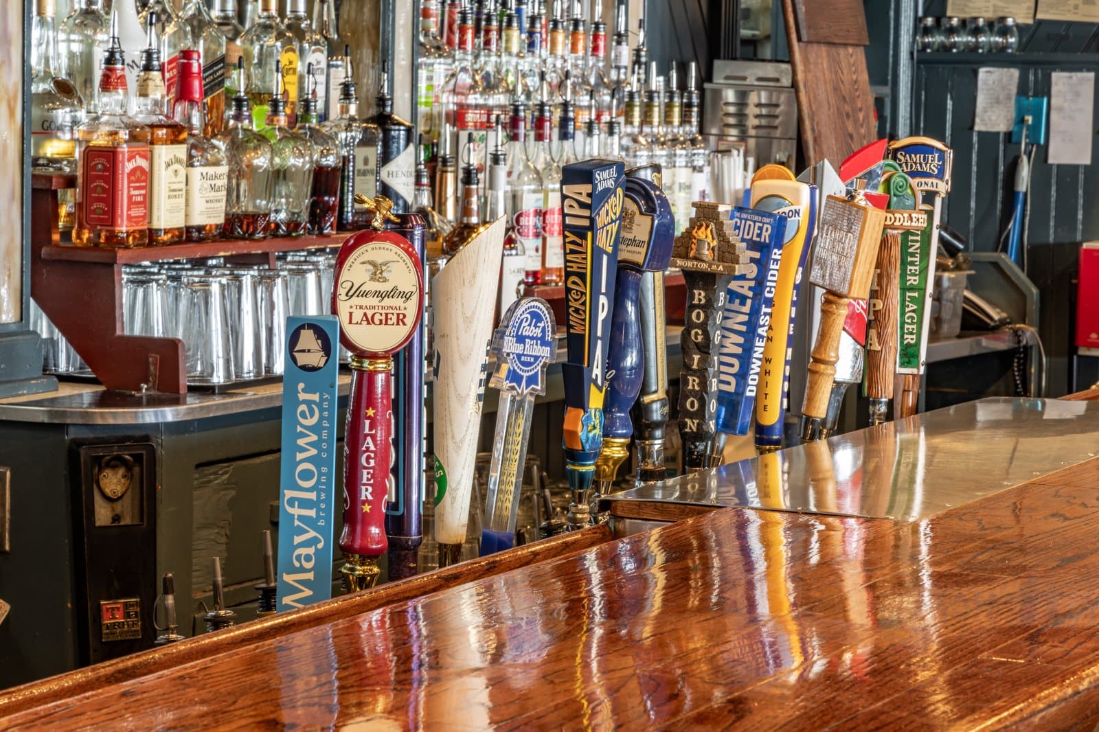 Rows of craft and domestic draft beer tap handles at the bar