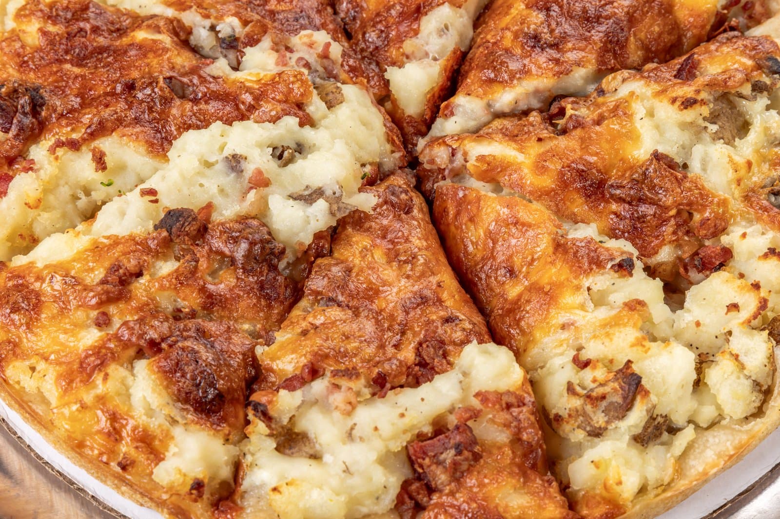 Loaded mashed potato and bacon pizza close-up