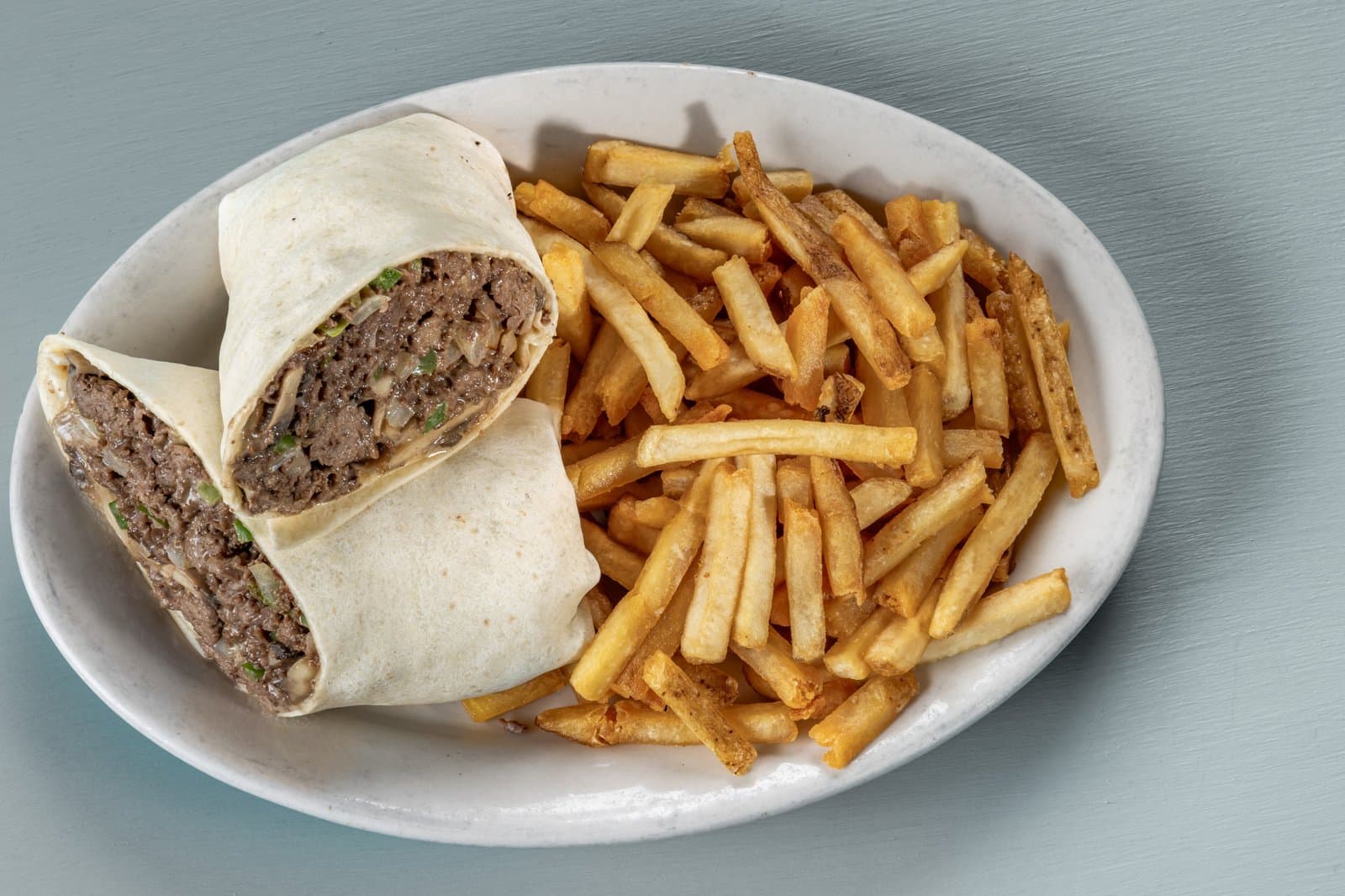 Steak and cheese wrap halves with french fries