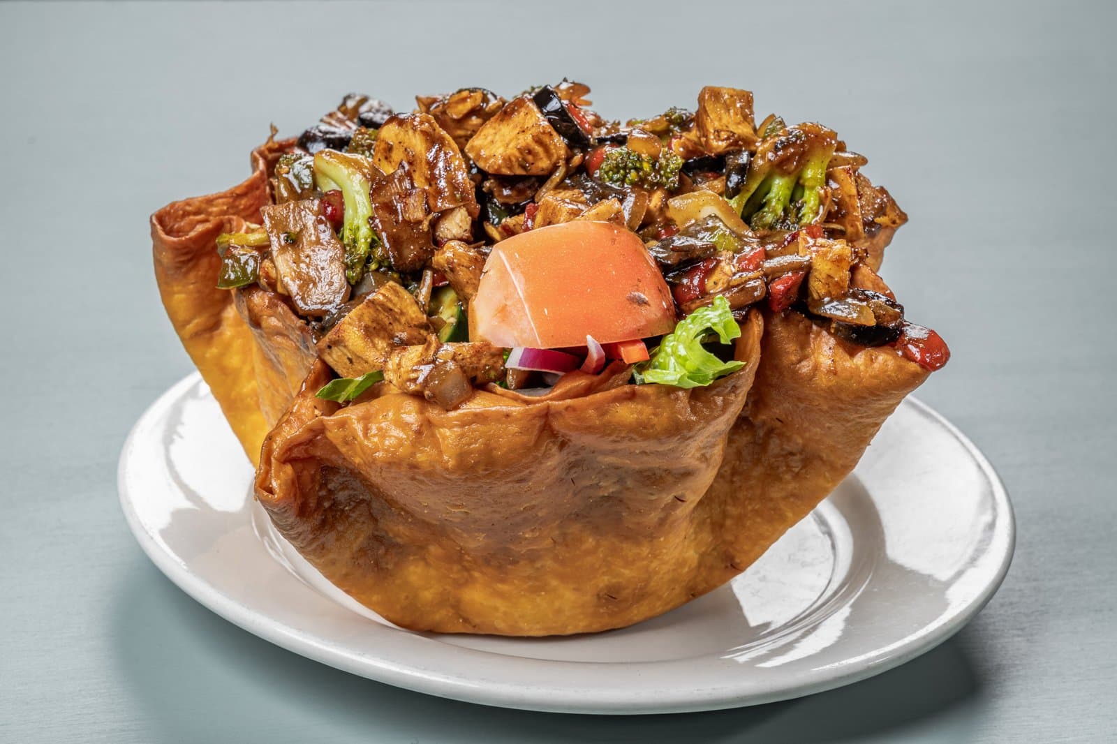 Grilled chicken and vegetables in a crispy tortilla bowl