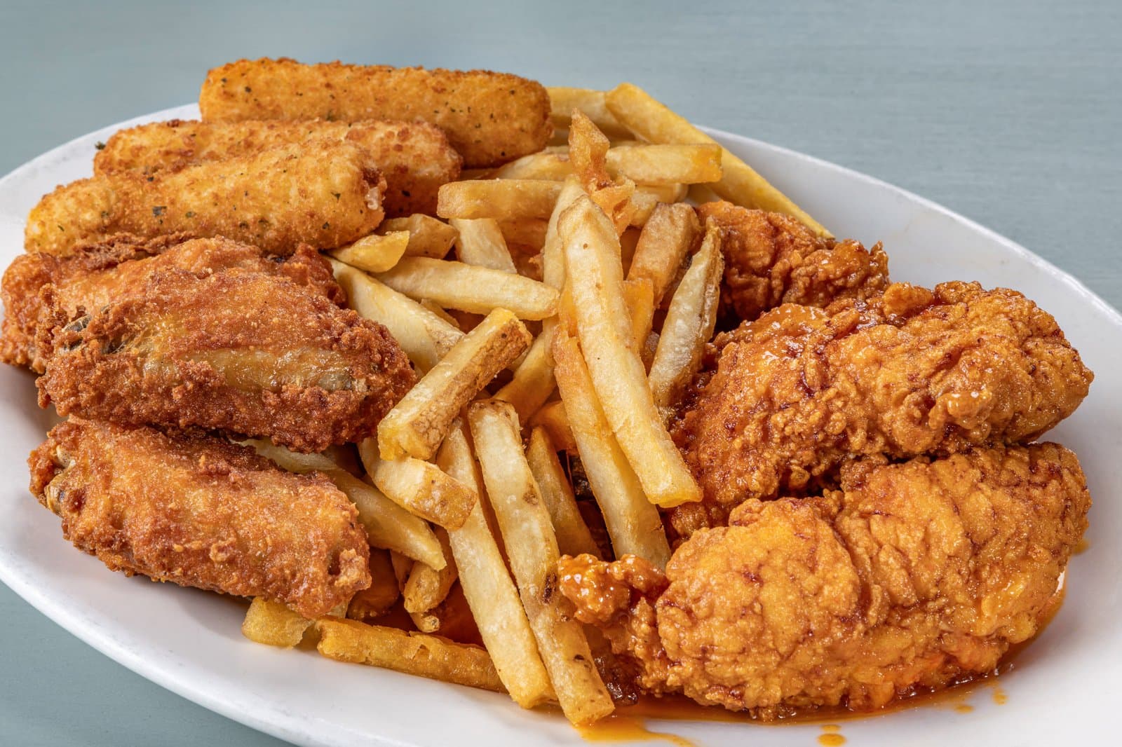 Combo platter of wings, buffalo tenders, mozzarella sticks, and fries